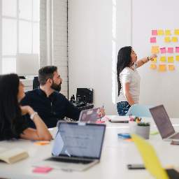 woman placing sticky notes on wall